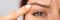 woman looking at her droopy eyelid