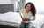Woman needing an Appendectomy having side pain while sitting on her bed at home