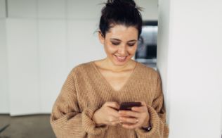 Woman smiling and looking at her phone