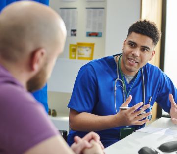 Male doctor speaking to male patient about common cancers in men