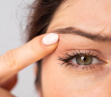 woman looking at her droopy eyelid