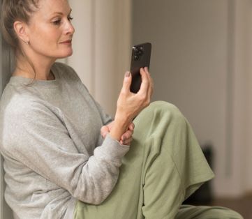Woman in her 40s access virtual mental health services on her phone